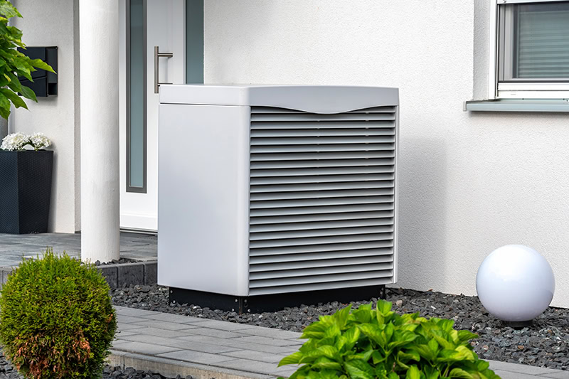 Modern heat pump in a front garden.